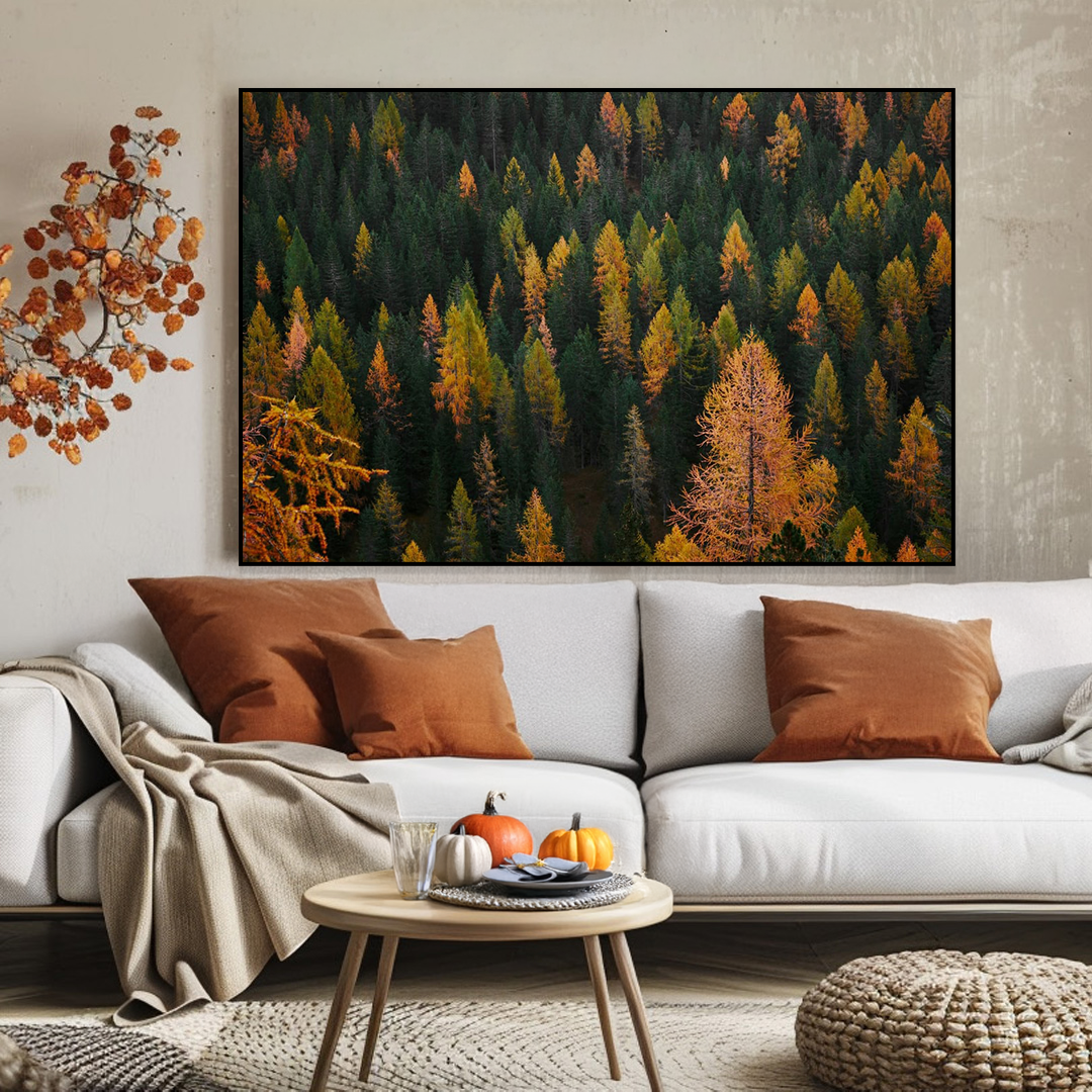 Living room with a forest painting above a white sofa with brown and beige pillows.