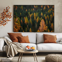 Living room with a forest painting above a white sofa with brown and beige pillows.
