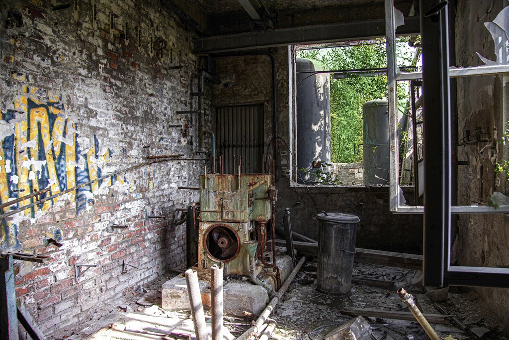 Antonio Friedemann - Explore a decaying industrial workshop in Leipzig, Germany, with rusted machinery and graffiti-covered walls.
