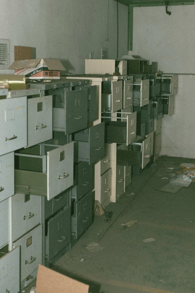Jack Krzysik - Explore the eerie ambiance of an abandoned room filled with open filing cabinets and scattered debris.