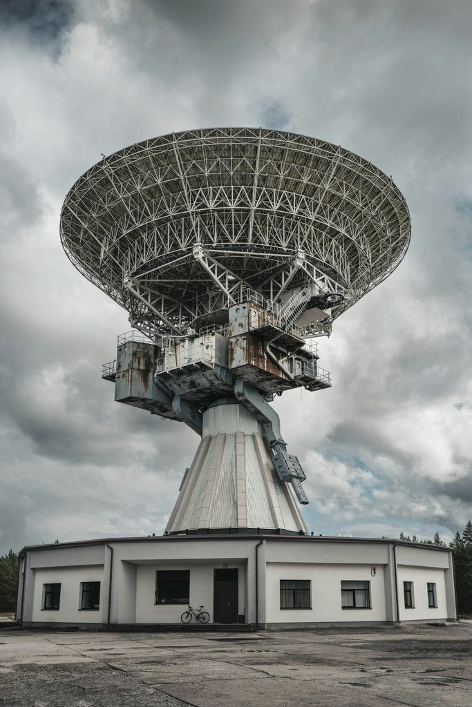 Raul Ling - Capture of a large radio telescope set against a moody sky, ideal for space and technology themes.