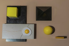 Mikhail Nilov - A creative studio composition of geometric shapes, including an egg, on a textured surface.
