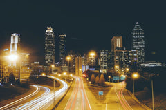 REX WAY - Stunning long exposure photo of Atlanta skyline at night with traffic light trails creating dynamic movement.