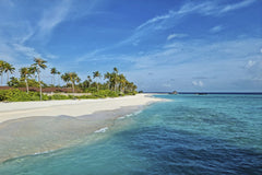 Geek Wandering - Experience the serene beauty of Maldives with turquoise waters and white sandy beach under a clear blue sky.