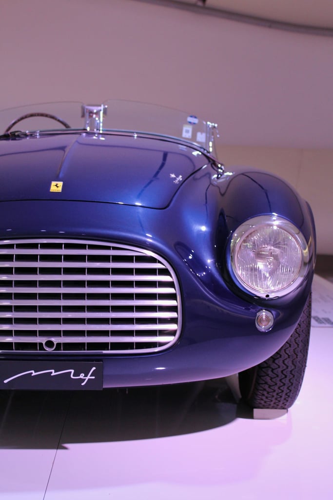 Ferrari in Midnight Blue front view with chrome grille, round headlamp, showcasing car wall art elegance and design.