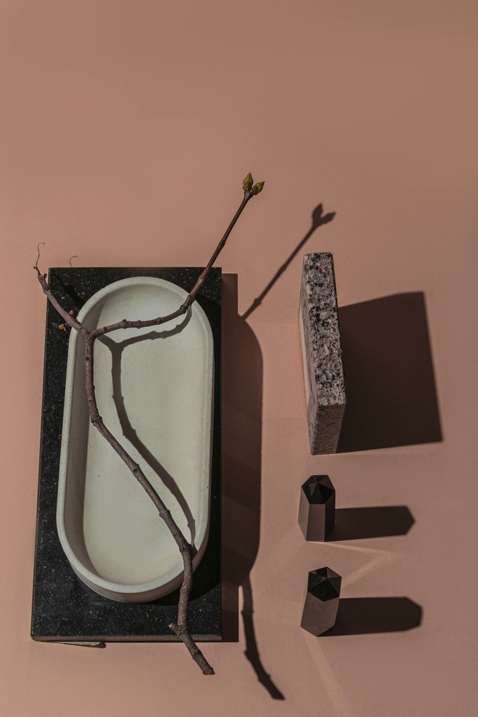 Mikhail Nilov - A creative still life featuring geometric shapes, a ceramic dish, and a natural twig on a warm background.