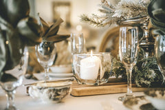 Todd Trapani - A beautifully arranged candlelit table with elegant glassware and festive decorations, perfect for a cozy dinner setting.