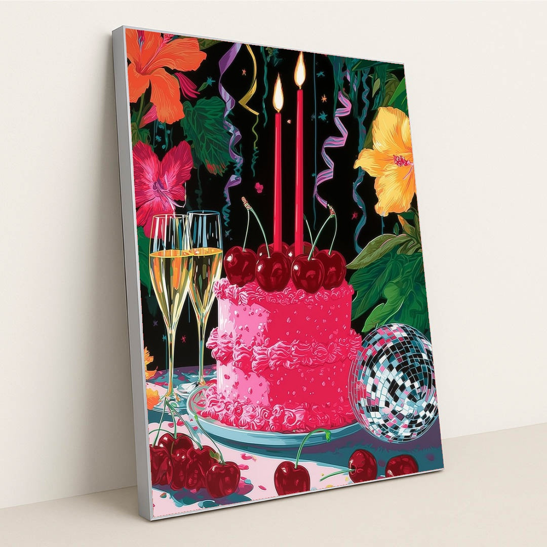 This artwork shows a festive pink cake with cherries, two lit candles, champagne glasses, a disco ball, and colorful hibiscus flowers, in a silver frame.