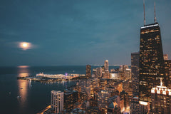 Willian Justen de Vasconcellos - Stunning aerial view of Chicago skyline under a full moon with lakefront lights.