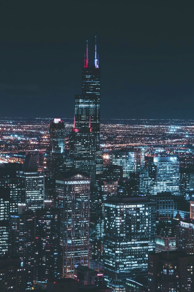 Guillermo Arroyo - Captivating aerial view of Chicago's skyline featuring the illuminated Willis Tower at night.