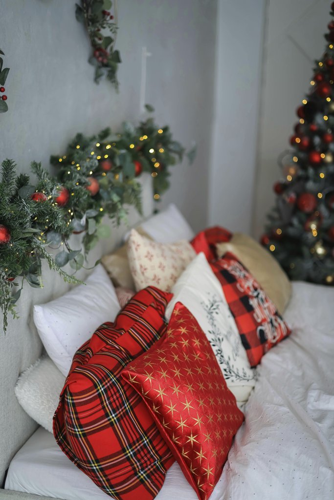 Valeria Boltneva - Cozy Christmas-themed bedroom with decorative pillows and festive garlands.