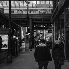 Qiang Lai - Monochromatic view of people walking under elevated train tracks in Chicago, IL, USA.