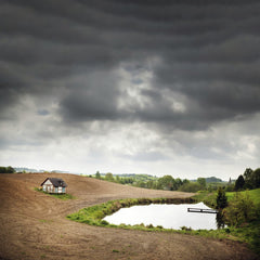 Piotr Arnoldes - Idyllic rural scene with cottage, pond, and dramatic sky in Szymbark, Poland.