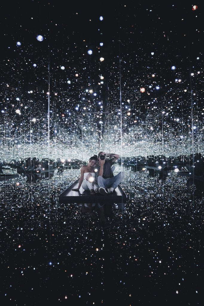 Brady Knoll - A couple enjoying a captivating infinity mirror room with reflective glittering lights.
