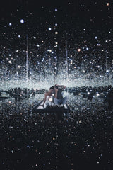 Brady Knoll - A couple enjoying a captivating infinity mirror room with reflective glittering lights.