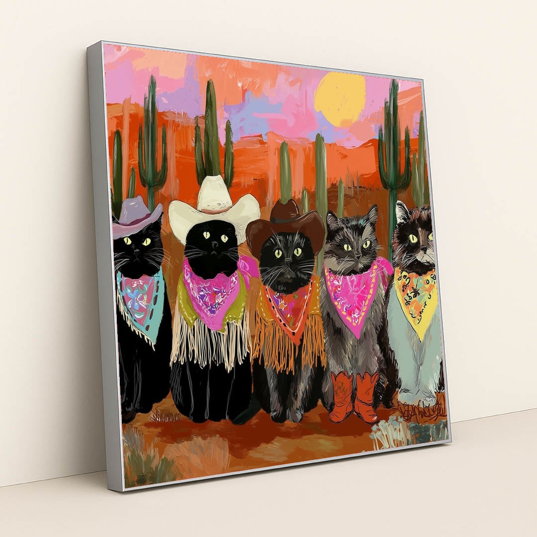 This artwork shows five cats in cowboy hats, bandanas, and boots posing in a colorful desert sunset scene with cacti, in a silver frame.