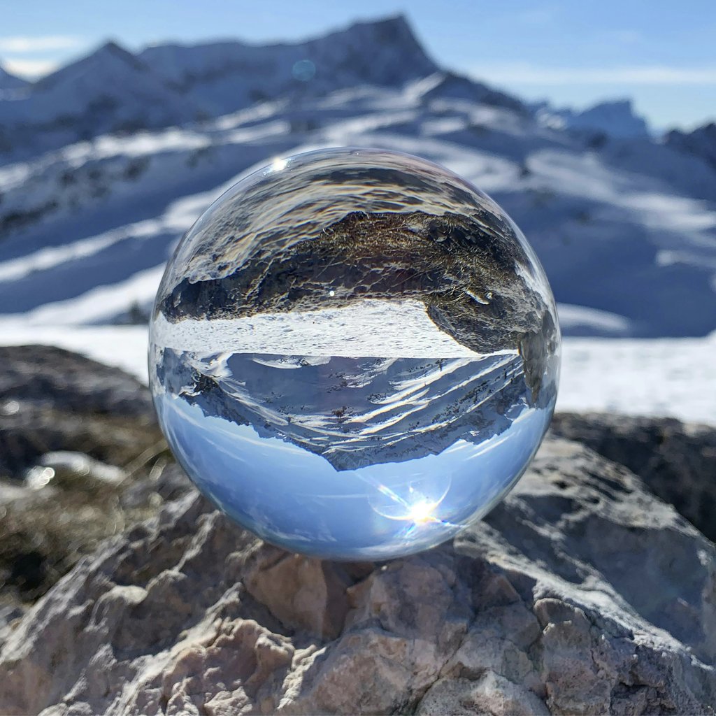 Andrea barsali - A crystal ball reflects stunning snowy mountains in Cortina d'Ampezzo, Italy.