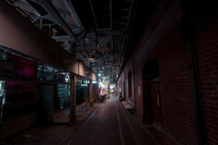 Jimmy Liao - Dark urban alley with industrial architecture and neon lighting creating a moody atmosphere.