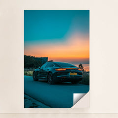 This photo shows the rear side of a dark Porsche Panamera 4S sedan parked on a road overlooking a colorful sunset, minimalist unframed style.