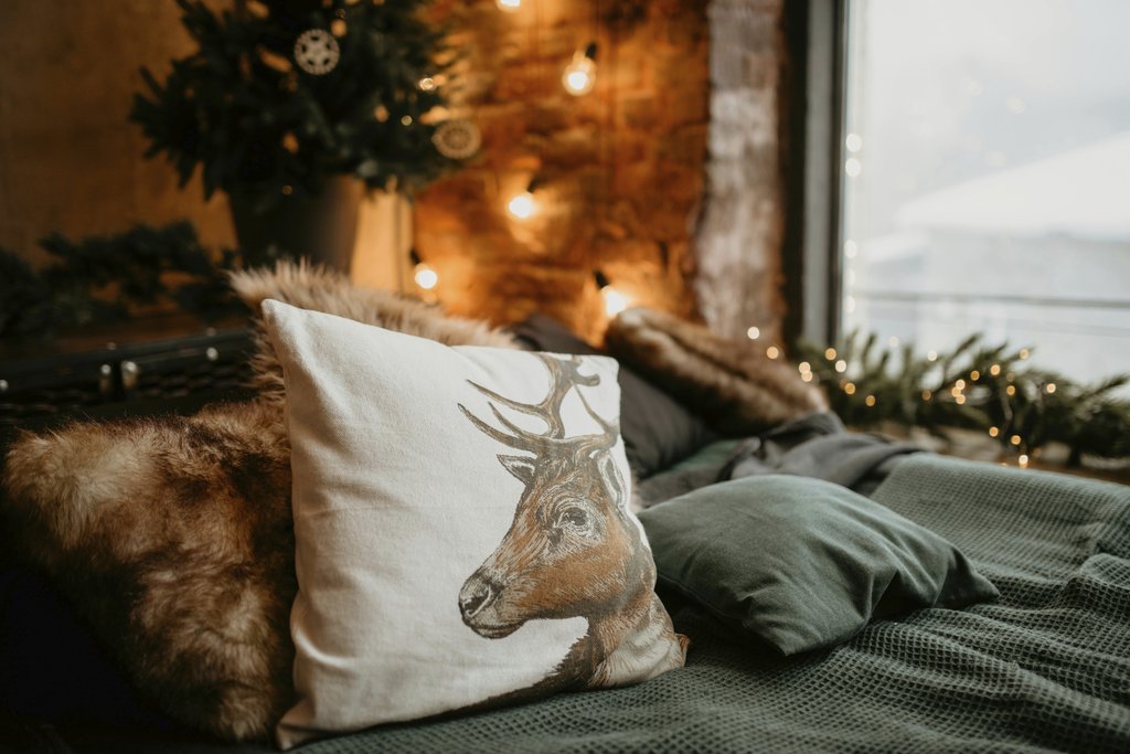 Dmitry Zvolskiy - Warm and inviting bedroom featuring festive decor and a deer pillow on a bed.