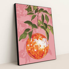 This artwork shows an orange disco ball hanging from a leafy branch against a pink background, in a black frame.