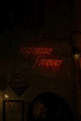 IDRISS BELHAMADIA - A dark moody café featuring a vibrant red 'espresso forever' neon sign.