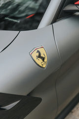 The Ferrari Crest in Matte Silver showcased on a sleek matte car surface, representing elegance in car wall art.
