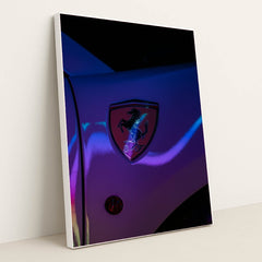 This photo shows a Ferrari prancing horse badge on a car fender illuminated with neon light reflections, in a white frame.