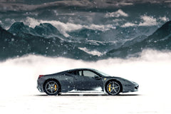 Ferrari 458 Italia Amidst the Alps showcasing its graphite-grey body in a snowy landscape with alpine mountains.