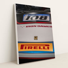 This photo shows a close-up of the hood of a Ferrari race car with Iron Dames and Pirelli logos, in a white frame.