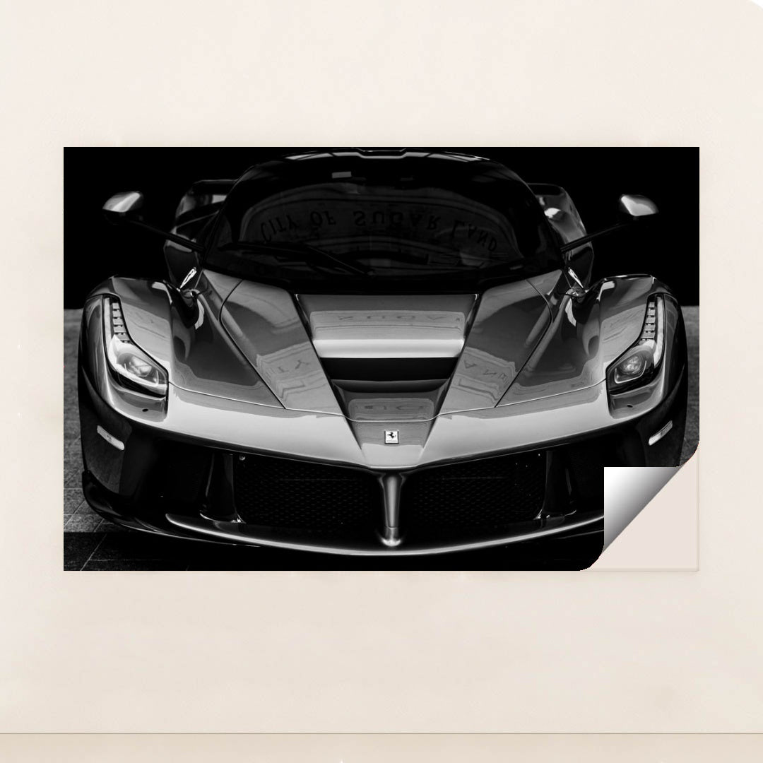 This photo shows the front view of a Ferrari hypercar in dramatic black and white, minimalist unframed style.