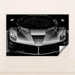 This photo shows the front view of a Ferrari hypercar in dramatic black and white, minimalist unframed style.
