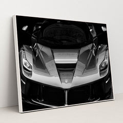 This photo shows the front view of a Ferrari hypercar in dramatic black and white, in a white frame.