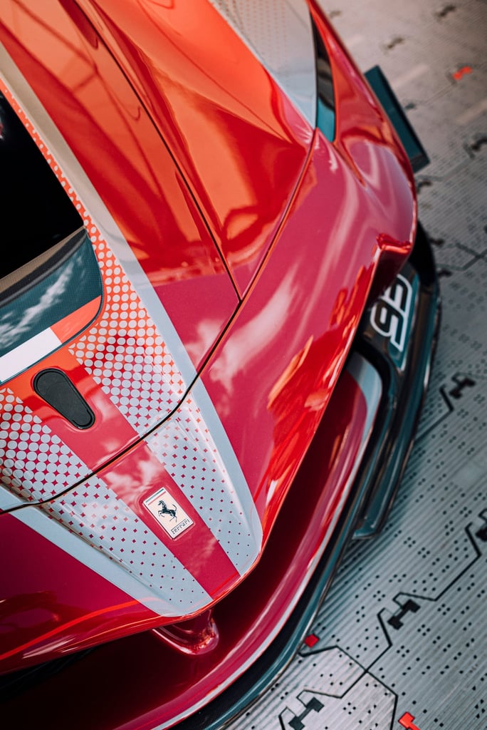 Close-up of Ferrari Frontline car wall art showcasing glossy red paint and bold silver stripe.