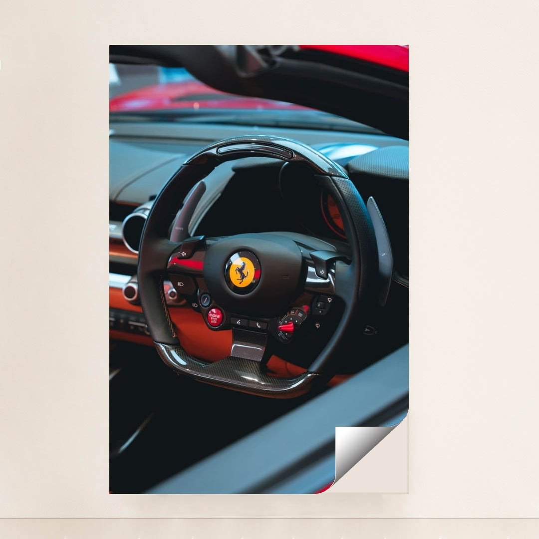 This photo shows the black carbon fiber steering wheel of a Ferrari, with red accents and dashboard controls, minimalist unframed style.