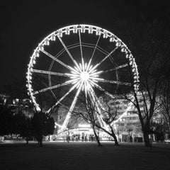Ivan Dražić - Black and white photo of a glowing Ferris wheel in Budapest at night.
