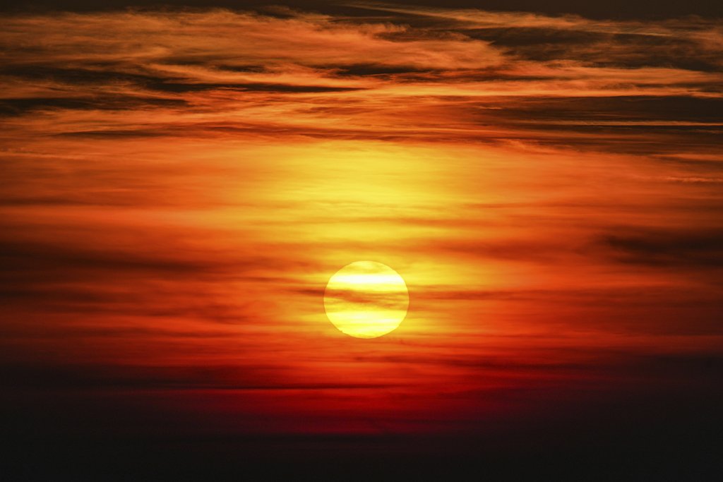 Nikola Tomašić - Captivating sunset with vibrant orange hues filling the sky and dramatic cloud formations.