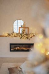 Valeria Boltneva - A modern interior featuring a cozy fireplace decorated with festive Christmas garlands and a stylish mirror above.