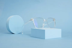 GlassesShop GS - Clear eyeglasses on blue geometric shapes, emphasizing minimalist design and clean lines.