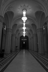 Botond Czapp - Elegant black-and-white view of an Art Deco hallway illuminated by ornate chandeliers.