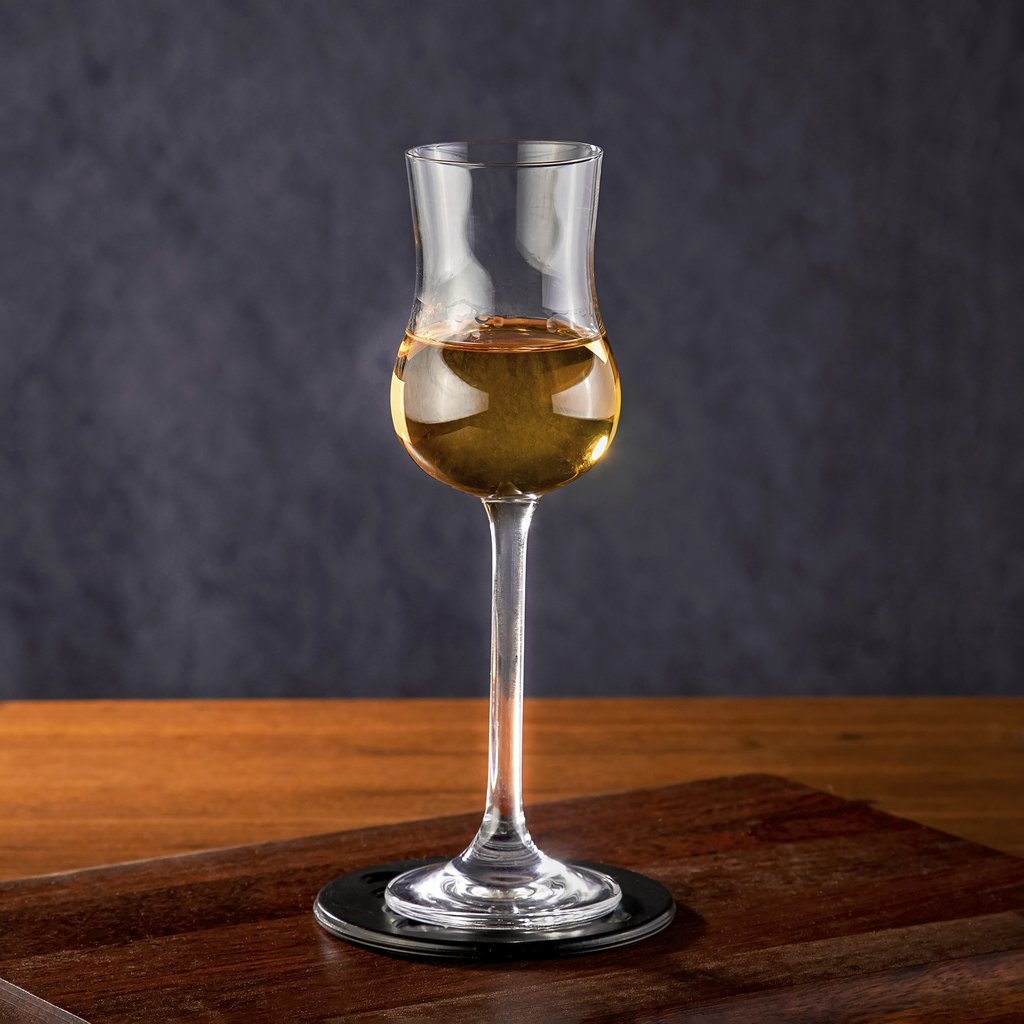 Marcelo Verfe - A single Glencairn glass filled with a golden spirit on a wooden surface.