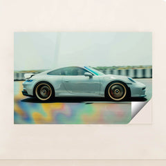 This photo shows a silver Porsche sports car in motion on a highway with colorful reflections on the road, unframed.