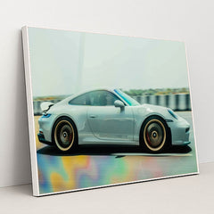 This photo shows a silver Porsche sports car in motion on a highway with colorful reflections on the road, in a white frame.