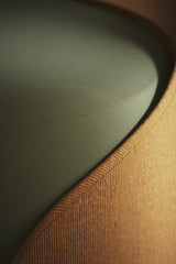 Bilal Mansuri - Close-up of a modern armchair showcasing its textured fabric and sleek design.