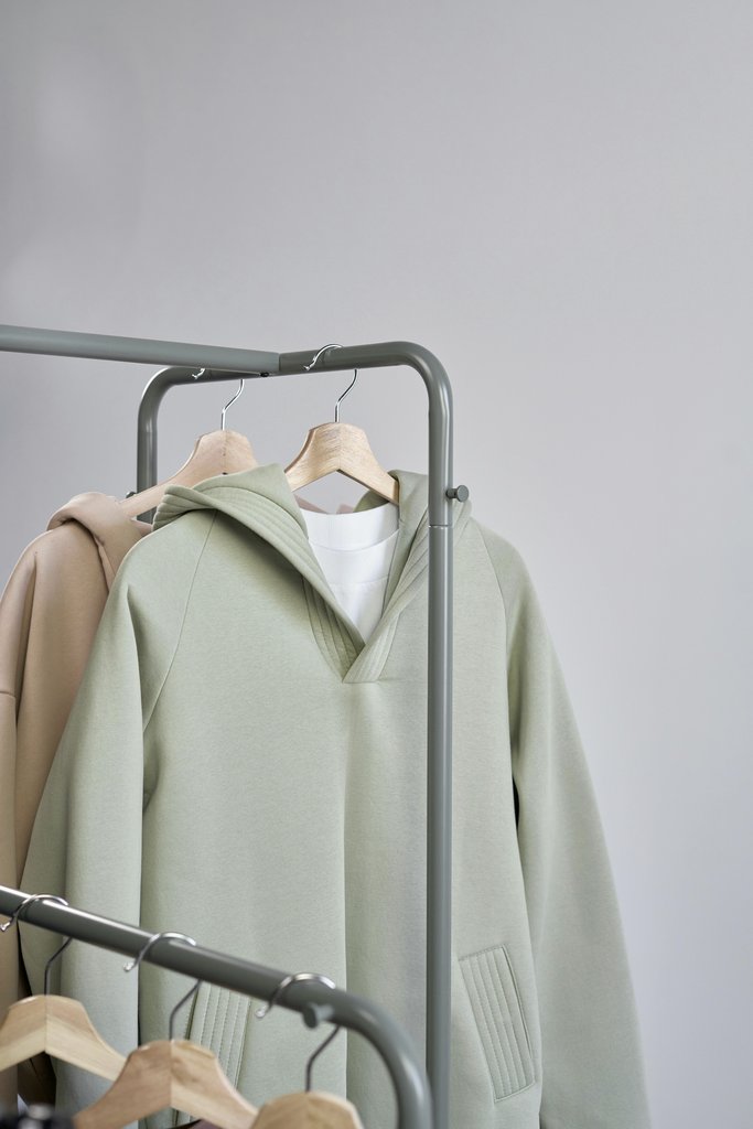 Ron Lach - Stylish minimalist sweatshirts displayed on hangers in a studio setting.
