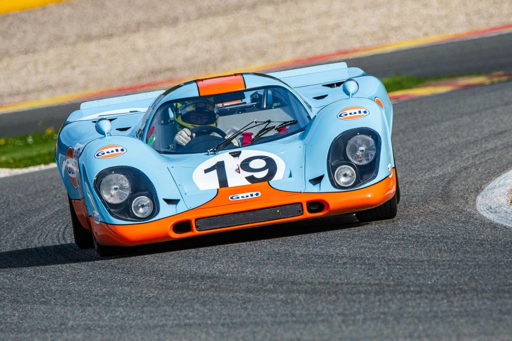 Porsche 917 in Gulf Racing Colors car wall art featuring legendary racing car in powder blue and orange, mid-corner on track.