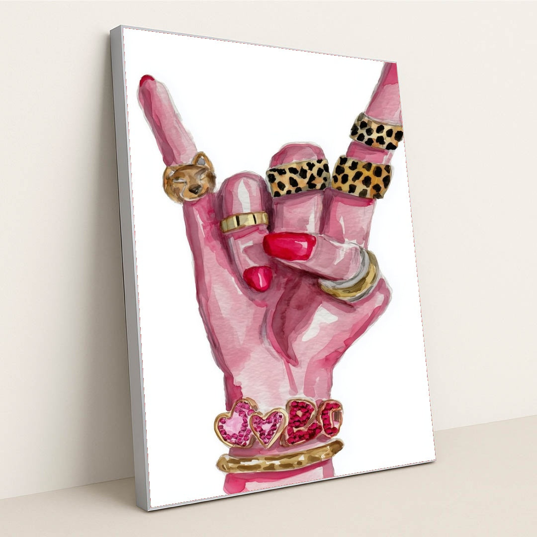 This artwork shows a hand with pink nails making a rock gesture, adorned with gold and animal print rings, and heart bracelets, in a silver frame.