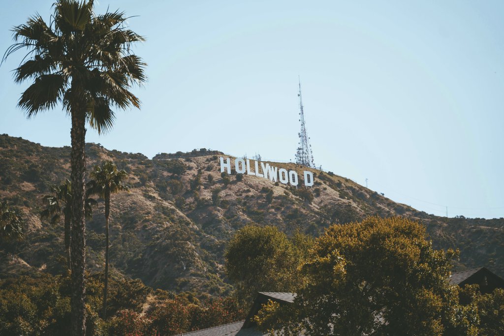 Alex Barnes - A scenic view of the Hollywood Sign surrounded by hills and palm trees in Los Angeles, California.