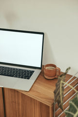 Cup of Couple - A minimalist workspace setup featuring a laptop and coffee mug on a wooden desk.