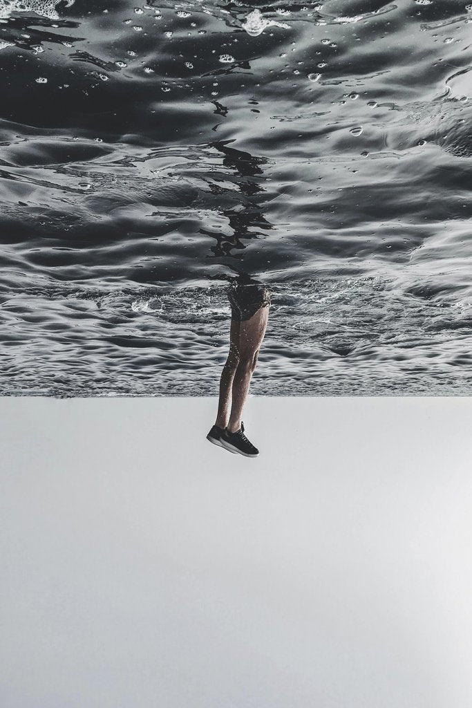 anouar olh - A surreal image of legs appearing to walk on the ocean surface, creating a dreamlike effect.